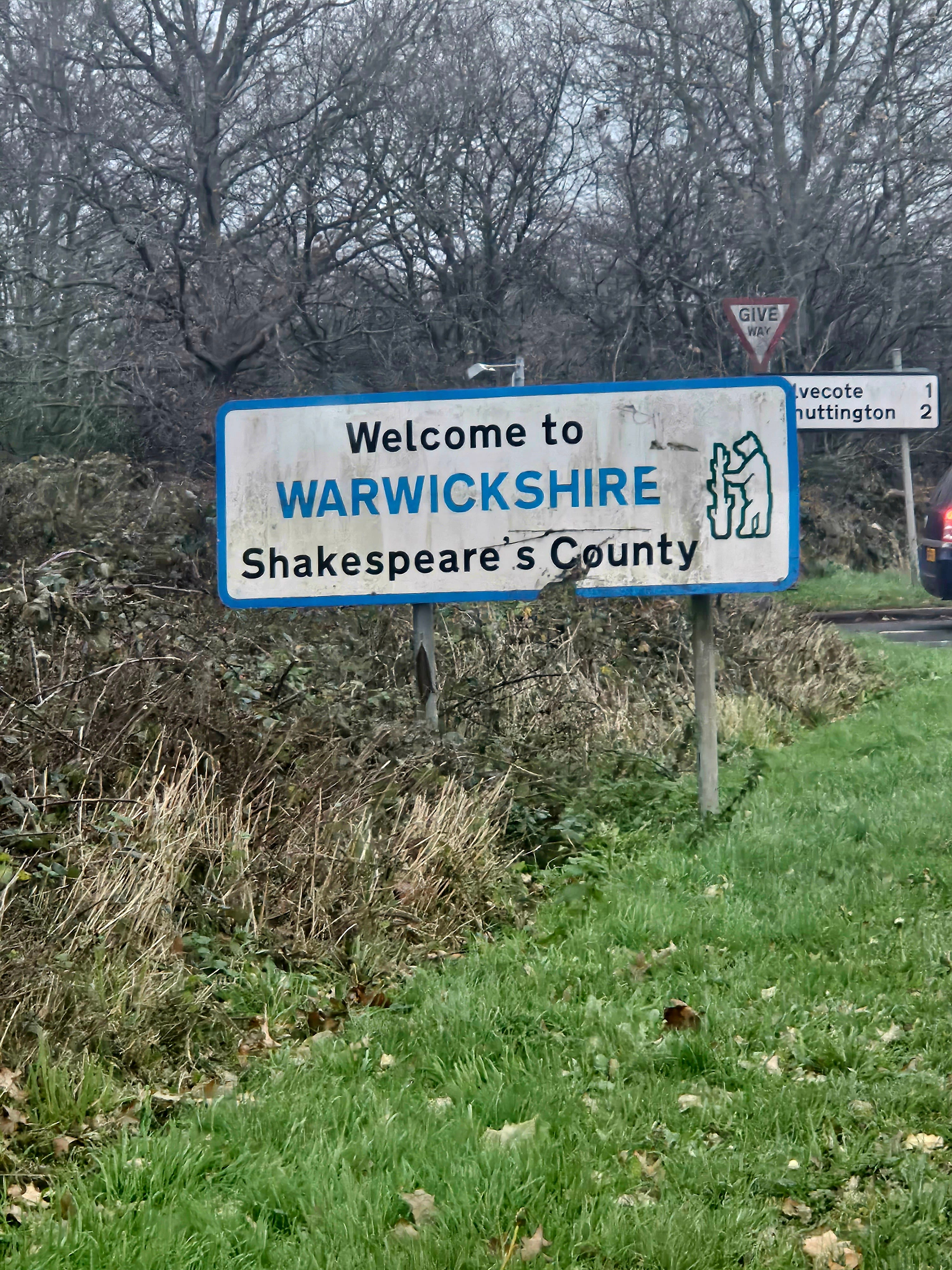 A roadside sign that reads "Welcome to Warwickshire Shakespeare's County"