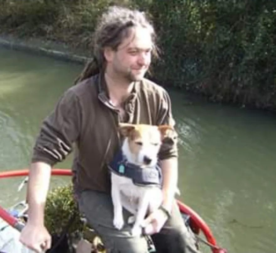 The same man and dog, some years later. Still on the back of a boat. The dog has a coat on this time